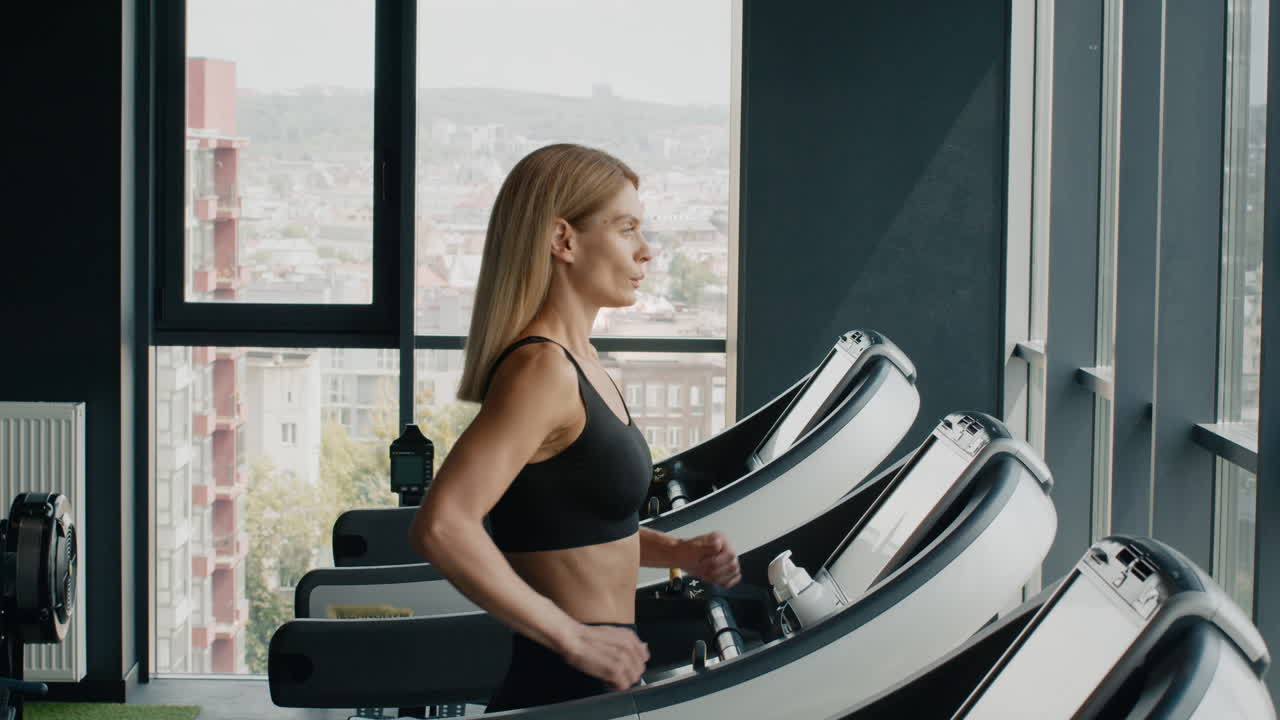Woman exercising on a treadmill in a modern gym