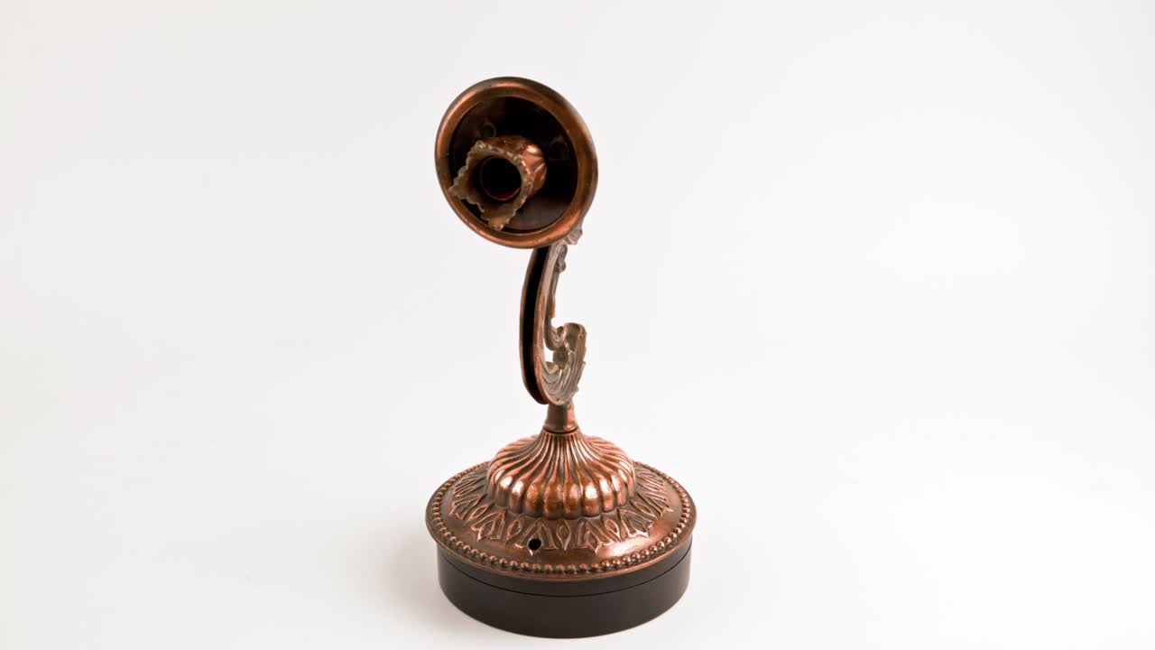 una parrilla de bronce falsa girando en una mesa giratoria sobre un fondo blanco