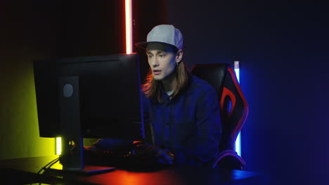 vista de cerca de un joven con gorra y jugando un juego en la computadora y molesto por perder 2