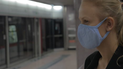 woman putting on mask in the subway