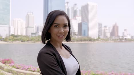 mujer de negocios sonriente en el parque de la ciudad