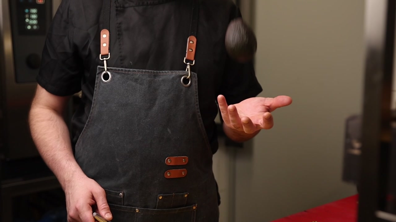 Koch schwenkt eine frische Avocado in einer Küche