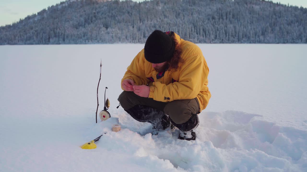 hombre instalando su trampa de pesca en hielo en un día de invierno en indre fosen, noruega - ancho