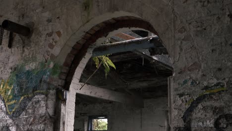 vista de un edificio abandonado a través de un arco de panorámica media