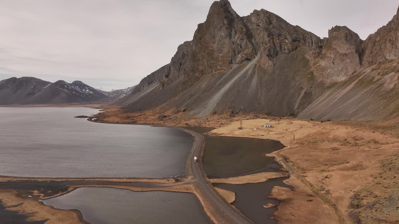 Coastal road winds below Stokksnes and Vestrahorn mountains on Iceland’s dramatic southeast coast