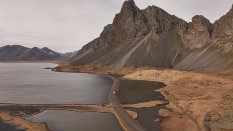 coastal road winds below stokksnes and vestrahorn mountains on iceland’s dramatic southeast coast