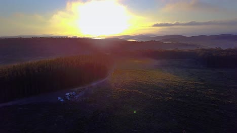 drone footage of sunrise over a forest covered in patches of fog