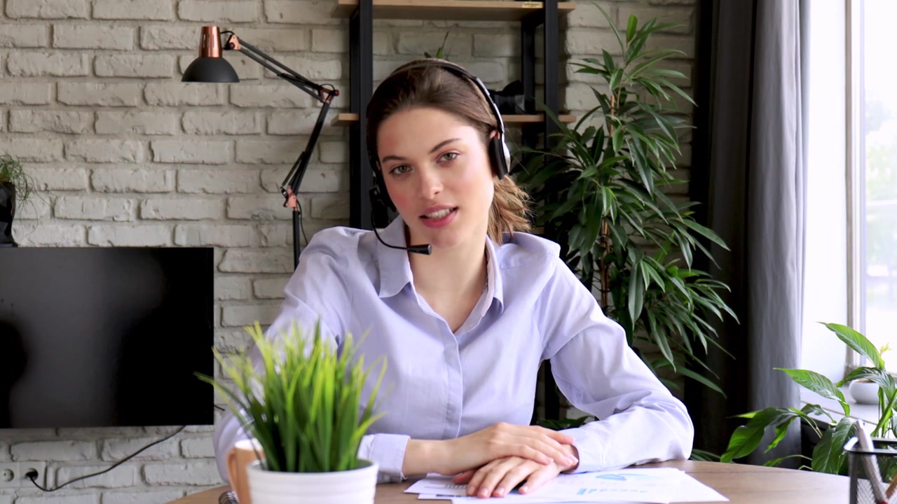 Mladá žena se sluchátky mluví během videohovoru