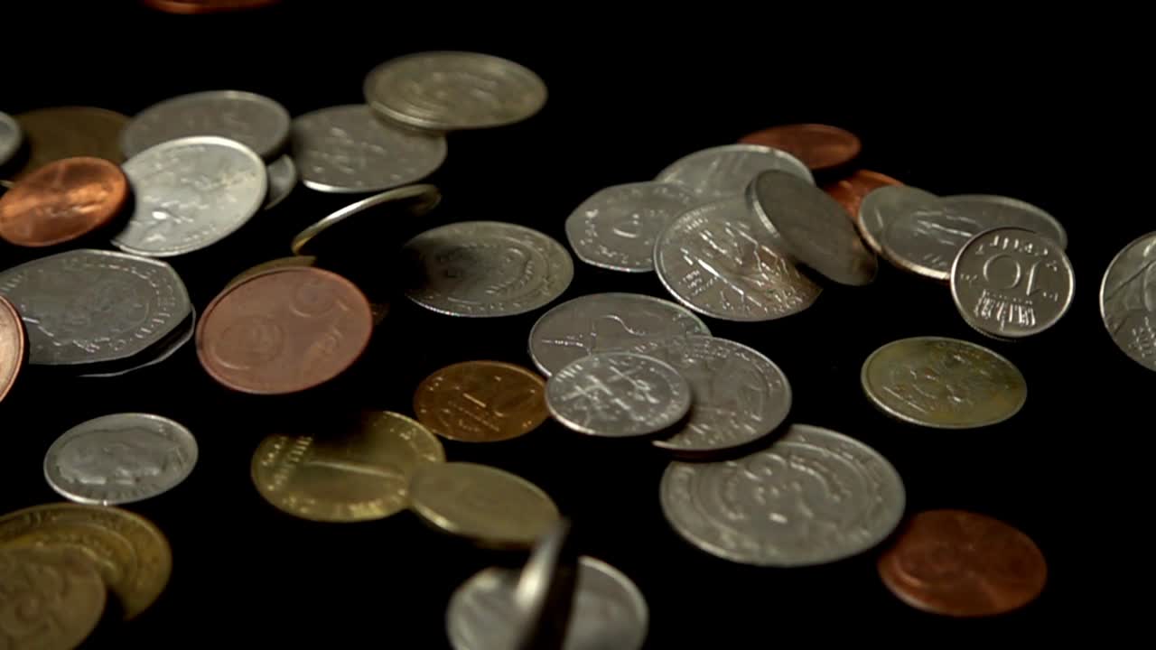 Monedas cayendo sobre un fondo negro. Cámara lenta