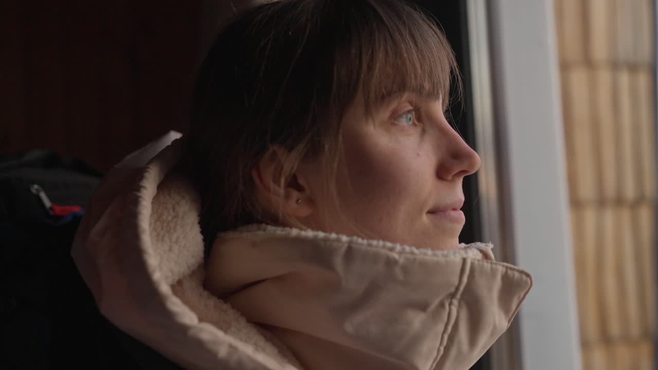 A woman with a backpack looking out the window