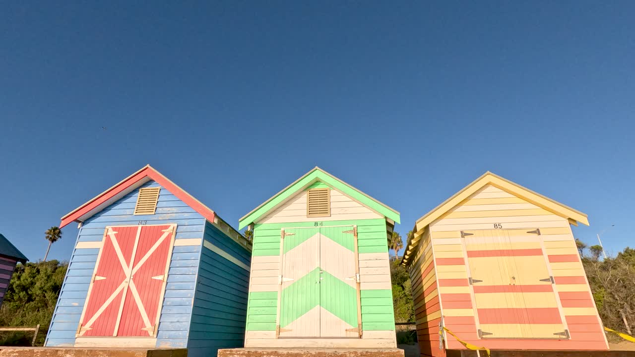 은 파란 하늘 아래 다채로운 해변 오두막