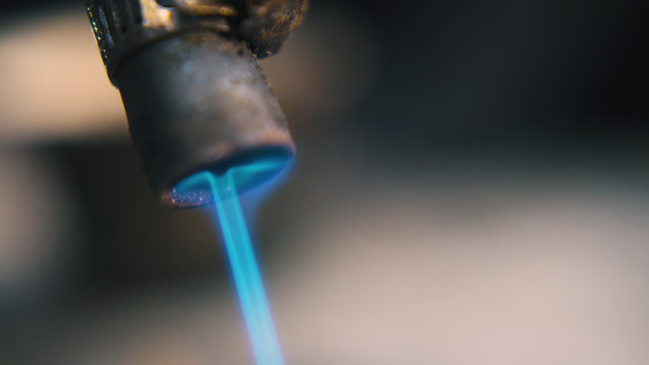 bruciatore a gas con fiamma blu utilizzato per elaborare gioielli da vicino