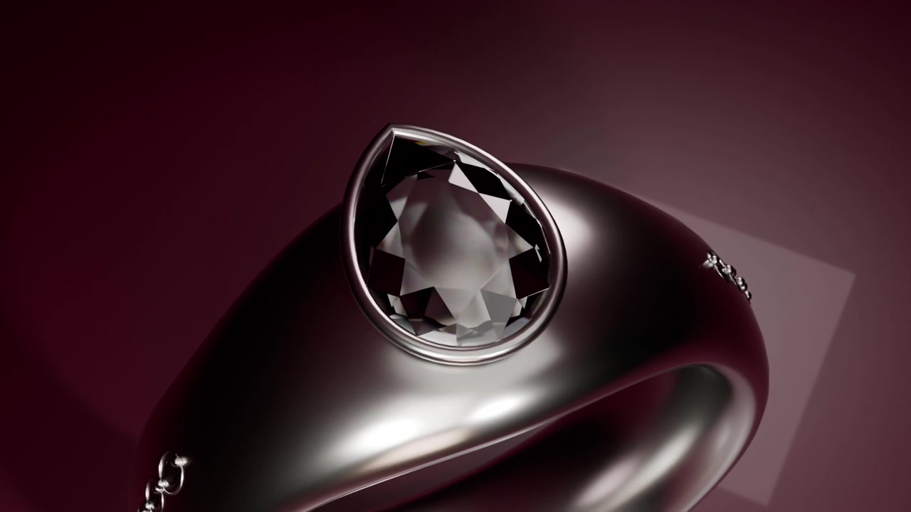 ターンテーブルが回転を開始。スタジオ内で暗い金属のリングが回り、洋ナシ型の宝石とスタッド（鋲）が映し出される