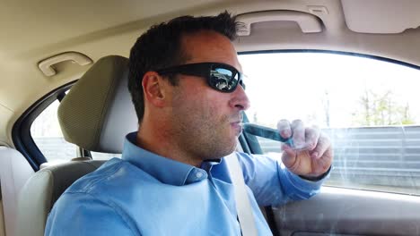 man vaping an e-cigarette in a car