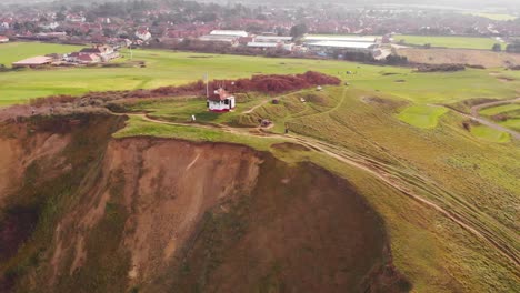 aerial - golf course and cliffs in sheringham, england, wide spinning shot