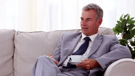 Smiling-businessman-drinking-a-cup-of-tea-