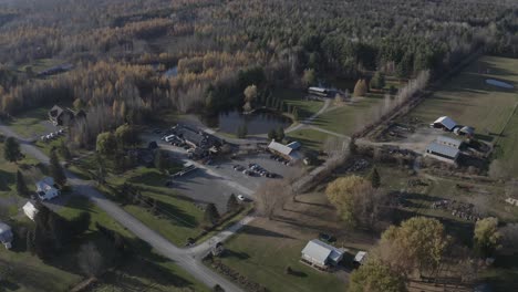 Drone-aerial-clip-of-a-beautiful-farmland-property-with-a-large-pond,-forest-and-a-bunch-of-old-buildings-in-the-Ottawa-region-