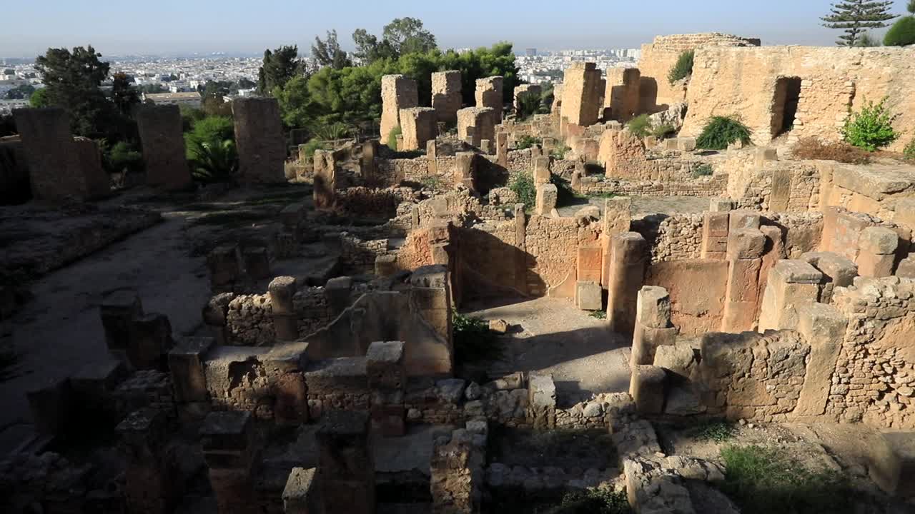 la luz del atardecer bañando las antiguas ruinas romanas en cartago, túnez, con sombras sobre el sitio histórico