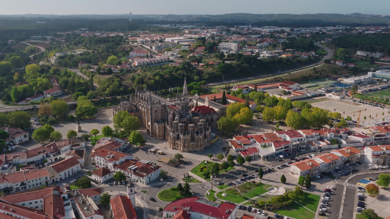 Mosteiro da Batalha aerial push‑in, slow forward glide toward ornate western façade and central nave
