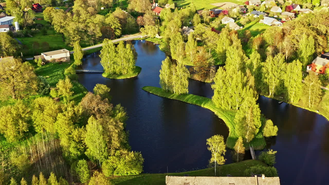 Aerial View of Lake with Islands Surrounded by Green Trees and Buildings in Town