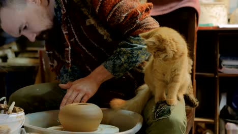 professional male potter working in workshop, studio