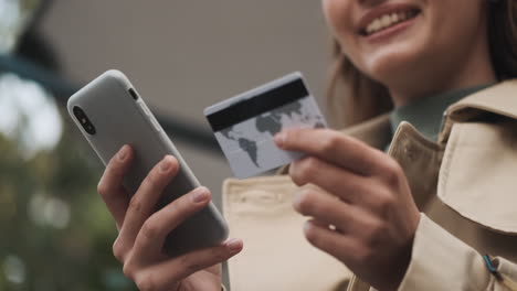 caucasian female student online shopping on smartphone outdoors.