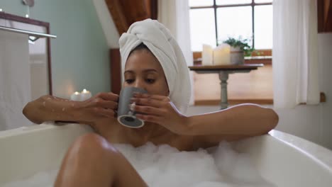 mixed race woman taking a bath and drinking coffee