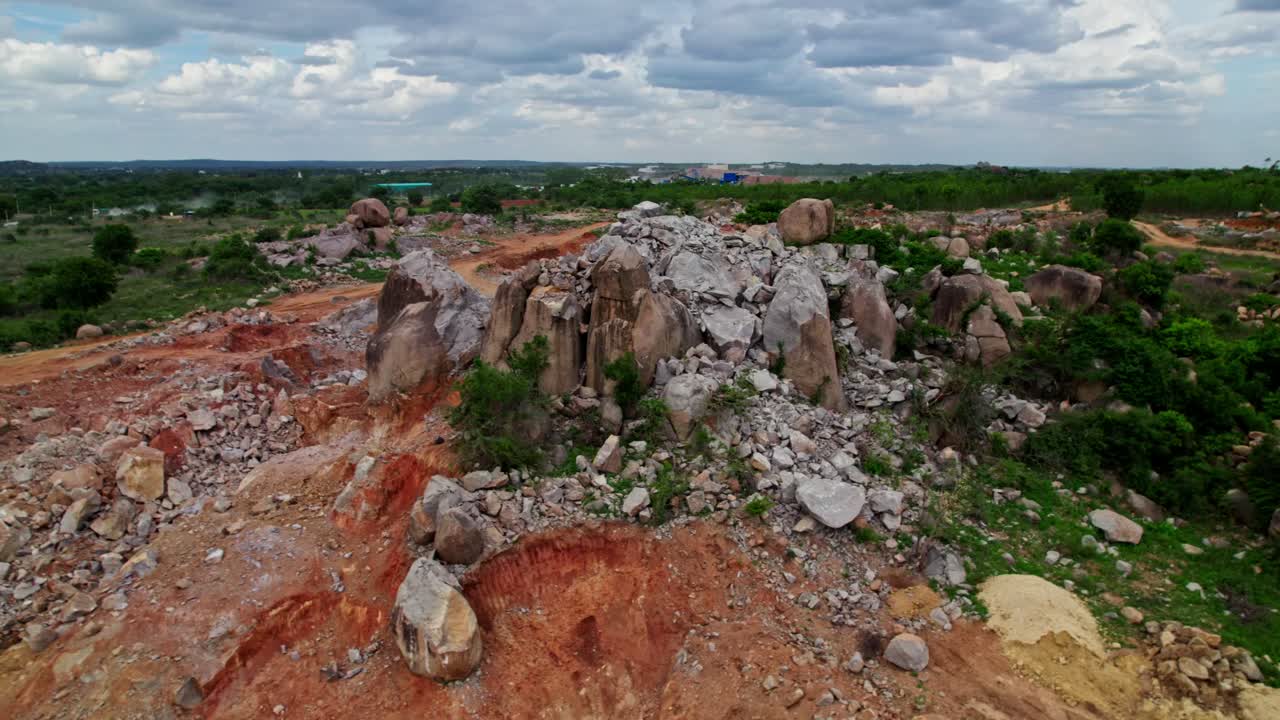 demolition of rock hills for construction land with surrounding greenery and rainy clouds on sky at telangana, india. day time, push back, drone shot, 4k.