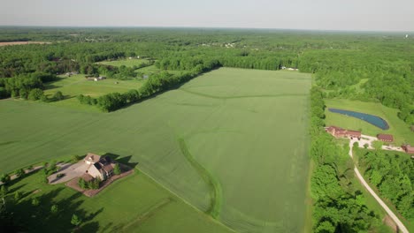 aerial view of farm house among green fields and slopes in rural countryside