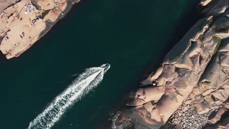 Barcos-Navegando-Rápidamente-Sobre-El-Agua-Oscura-Entre-Las-Islas-Rocosas-En-Stångenäs,-Lysekil,-Suecia---Toma-Aérea