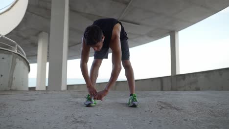 Un-Atleta-Con-Ropa-Deportiva-Se-Calienta-En-Un-Aparcamiento-De-La-Ciudad.