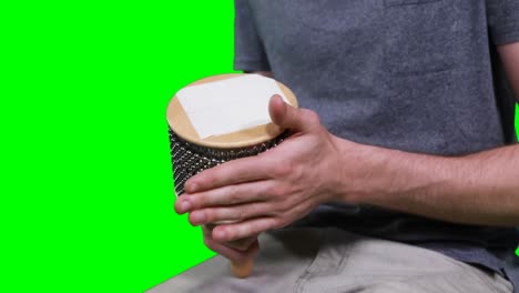 mid section of male musician playing cabasa