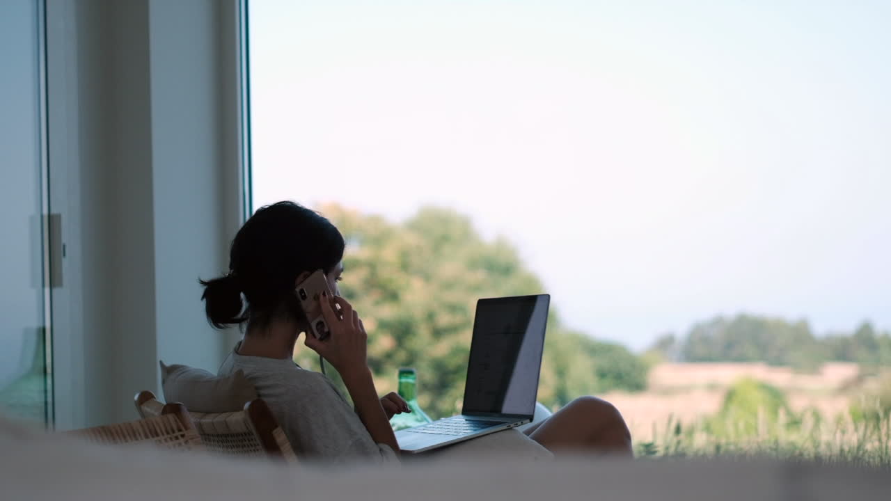 프리랜서 라이프 스타일: 생산적인 여성은  ⁇ 빛 창에서 노트북과 함께 호출됩니다.