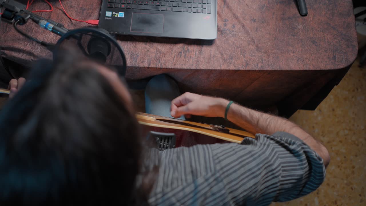 Person playing guitar in a home studio