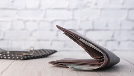 billetera de cuero marrón con dinero en la mesa de madera