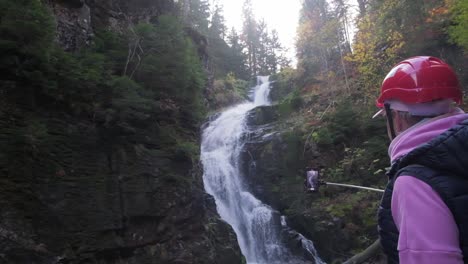 a male tourist takes photos on a smartphone near a waterfall vacation a male tourist takes photos on a smartphone near a waterfall vacation