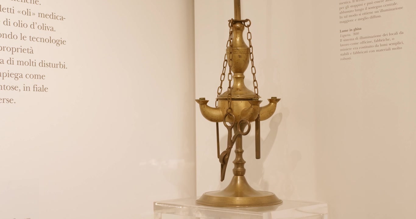 Antica lampada a olio in ottone esposta nel museo dell'olio Carlo Carli, sala espositiva bianca