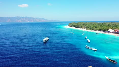 Barcos-Turísticos-Anclados-En-La-Laguna-Azul-Celeste-Cerca-Del-Complejo-Ubicado-En-La-Costa-De-Una-Isla-Tropical-Con-Playa-De-Arena-Blanca-Y-Bosque-De-árboles-En-Bali