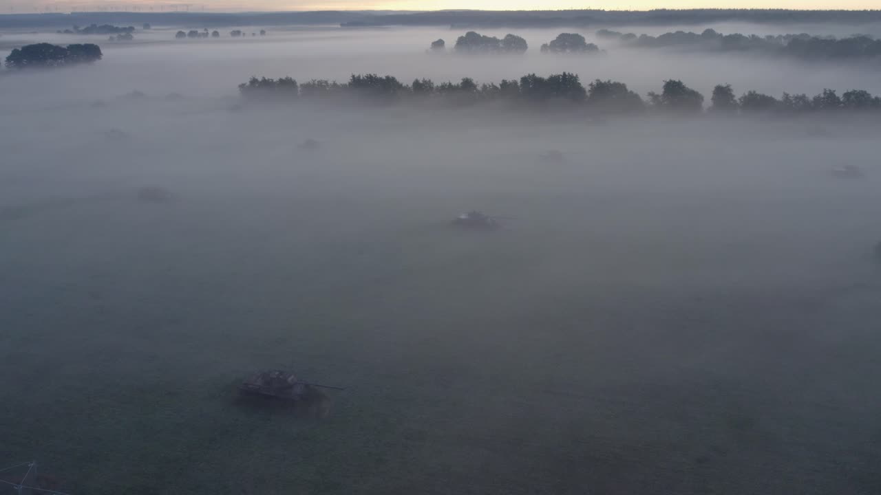 Pemandangan udara tank militer tua di padang rumput dengan kabut matahari terbit di Sogel, Jerman, dengan cahaya memukau, suasana tenang, rekaman drone berkualitas tinggi menampakkan pemandangan damai