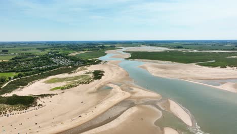 lake and river flowing through green polder landscape at netherlands and belgium border, het zwin nature reserve