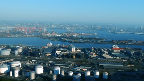 aerial footage taken from a drone of a harbour with ships and containers and industrial hubs