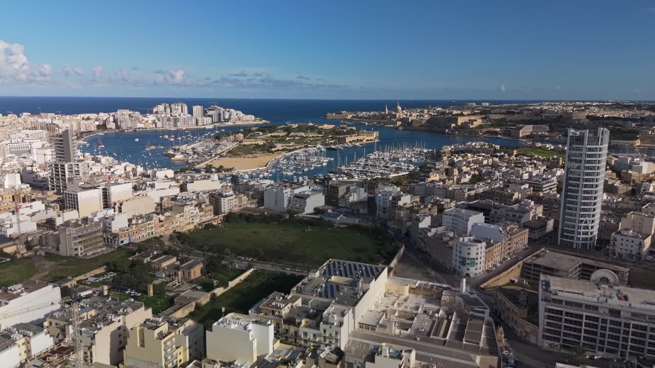 Aerial view of Malta's vibrant harbor cityscape around the Manoel Island, including Sliema, Msida, Ta' Xbiex and Valletta, highlighting the Mediterranean island's urban charm and coastal allure