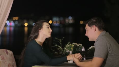 romantic couple holding hands on a date at night