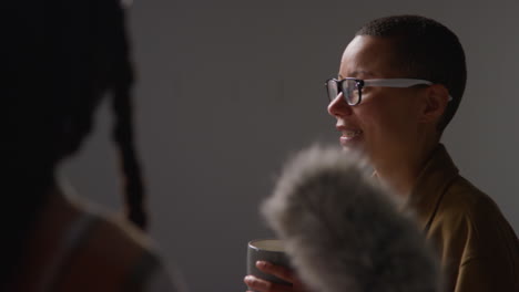 close up of female film director giving direction to actors shooting movie or video in studio