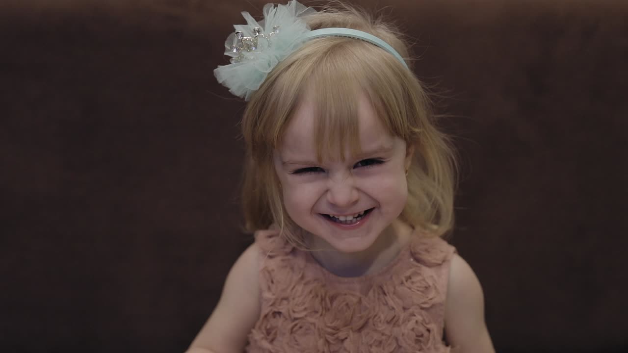 una niña feliz de tres años. una niña rubia linda. ojos marrones. una chica linda sonriendo