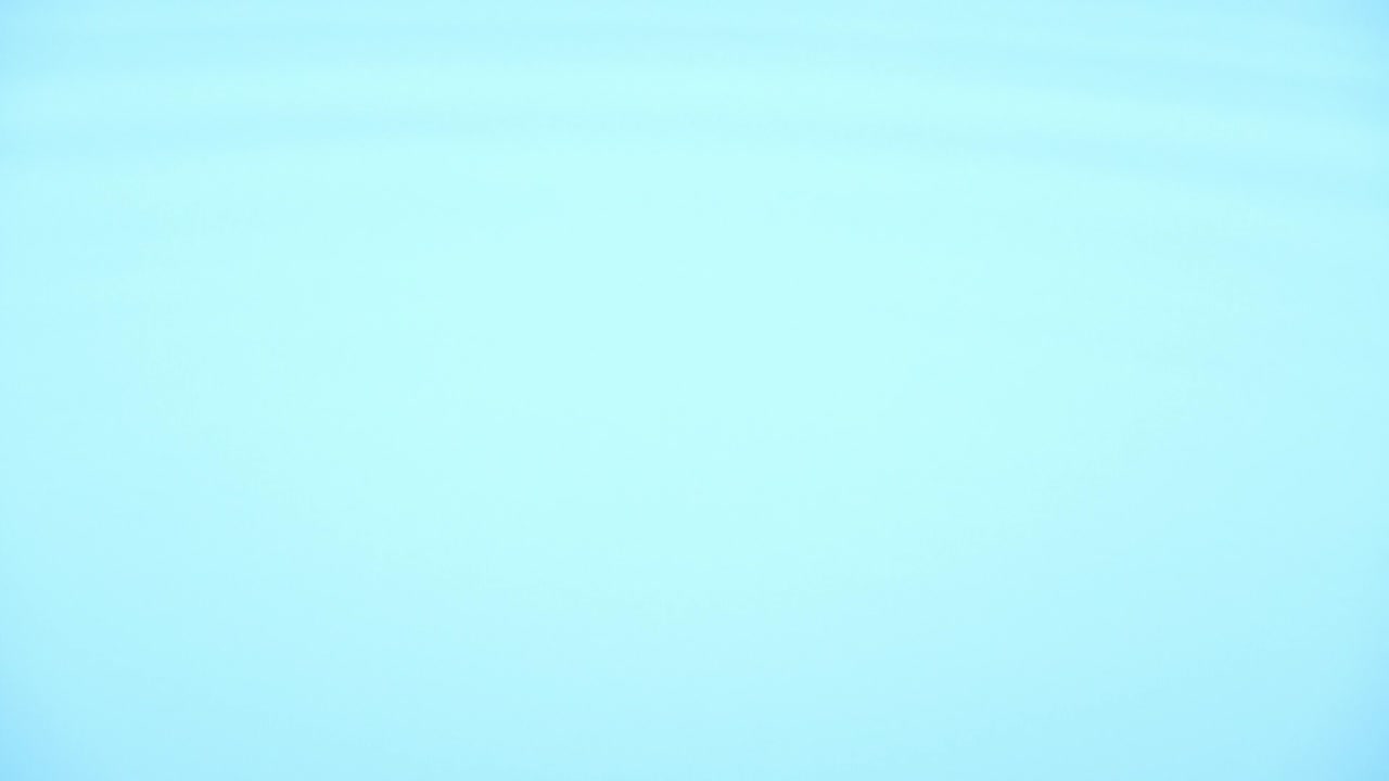 Scena al rallentatore con vista laterale di una goccia d'acqua che cade su una superficie d'acqua, isolata su sfondo blu. Goccia di pioggia che cade a terra, concetto di acqua potabile, laboratorio per esperimenti scientifici sulla lunghezza d'onda.