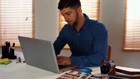 diseñador gráfico masculino usando una computadora portátil