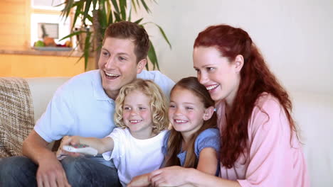 children watching the television with their parents