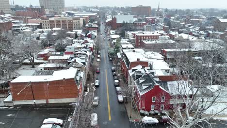 Aerial-approaching-shot-of-small-American-city-street-during-snowfall