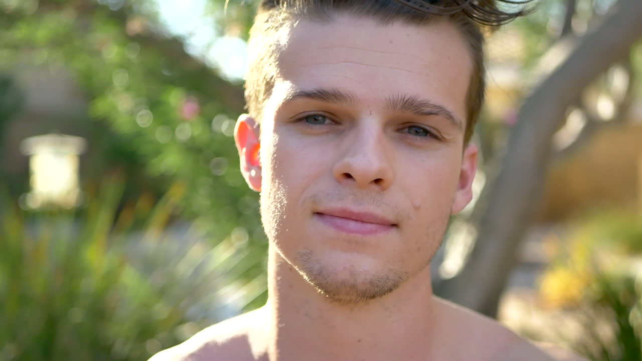 건강한 젊은 매력적인 백인 남자가 긍정과 좋은 진동에 대한 명상에 앉아있는 동안 손으로 심장을 사랑하는 기호를 만니다.